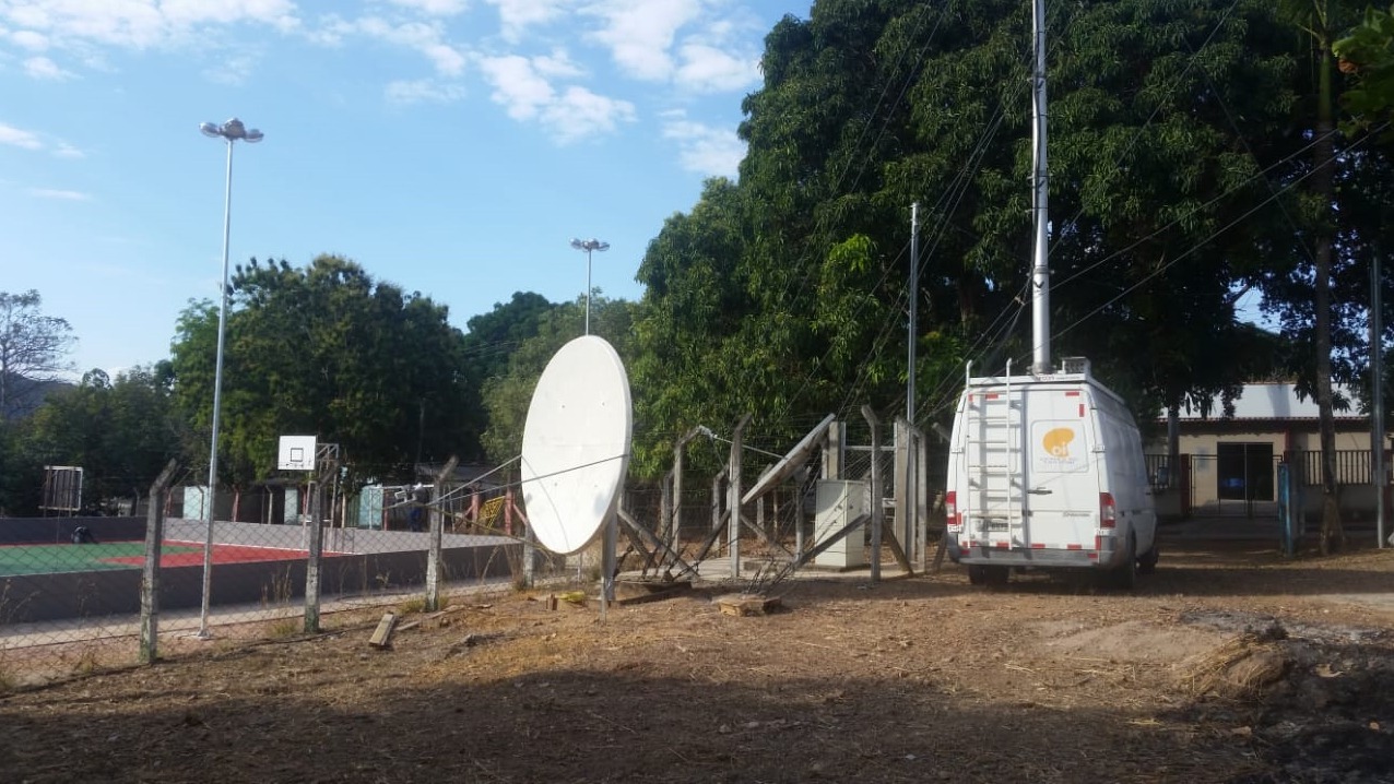 Antena de comunicação via satélite e veículo de apoio na área do evento