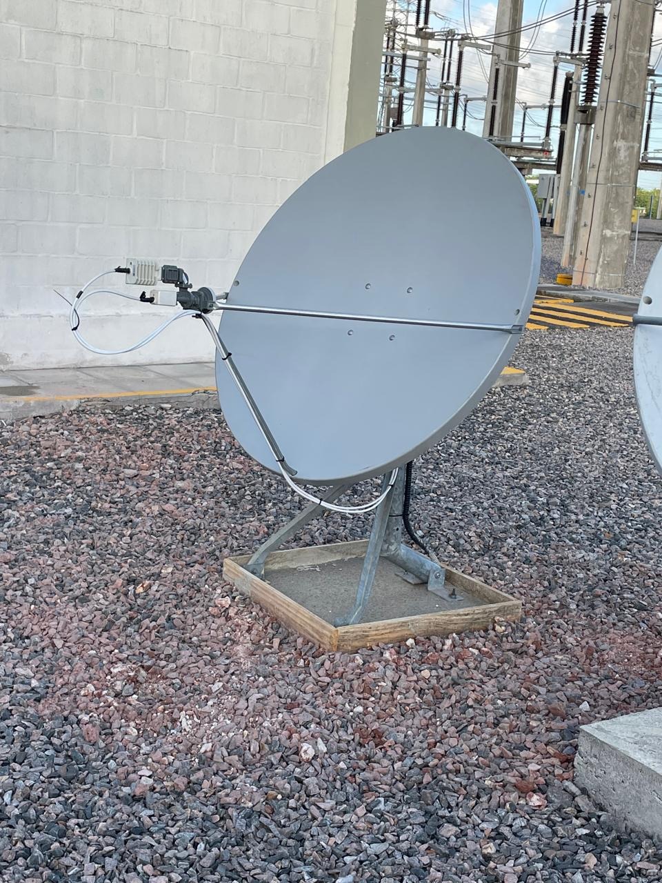 Antena parabólica instalada sobre base em área de subestação